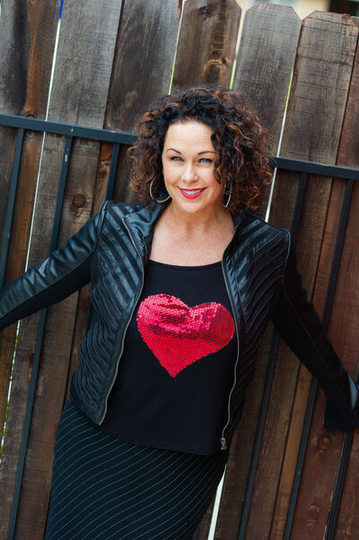 Creative headshot of Shawn Marie Turri wearing a black shirt with a sequin red heart and black leather jacket for her CRAVE Women branding photographer photoshoot.