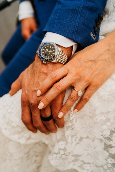 Close-up of elopement couple’s hands showing wedding rings and elegant details during an intimate moment.
