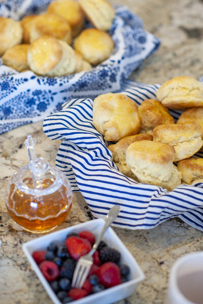 A photo of biscuits, honey, and berries for a product photo
