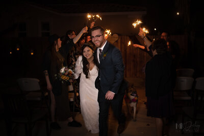 Sparkler exit mk delacy photography bride in white dress and simple flower bouquet groom in blue suit and tie wearing glasses