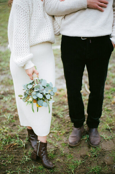 bride and groom standing together holding bouquet during their elopement in vermont