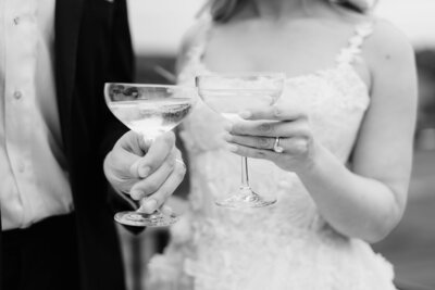 A bride and groom toast each other with their champagne glasses