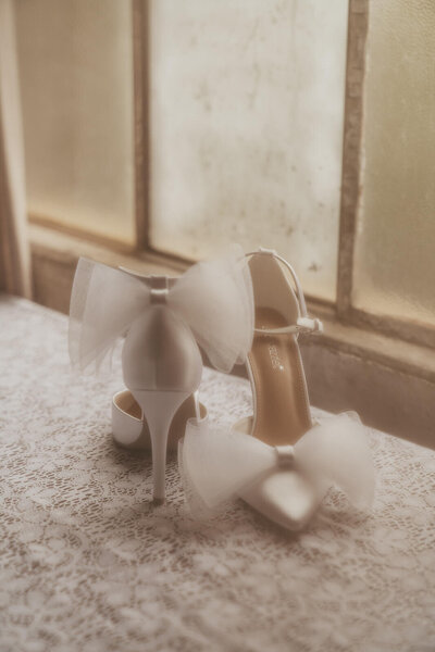 Film photograph of bride's shoes adorned with bows