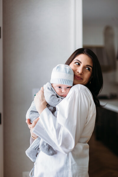 Newborn Photographer,  a mother holds her baby and smiles