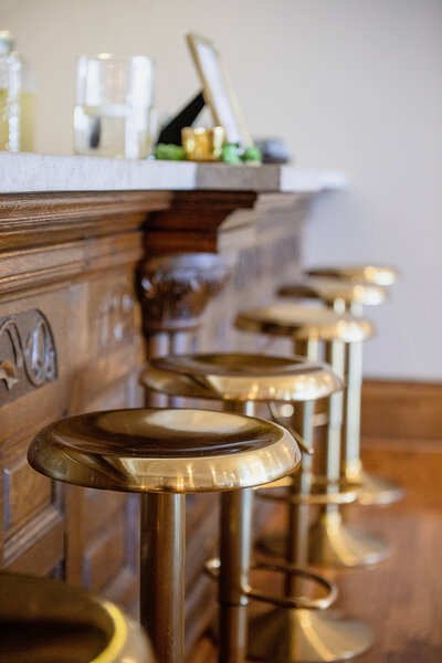 gold bar stools at limestone topped antique bar