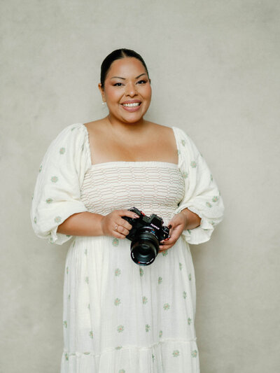 Photo of Jennifer Nolan wearing an Anthropologie dress while she holds her camera.