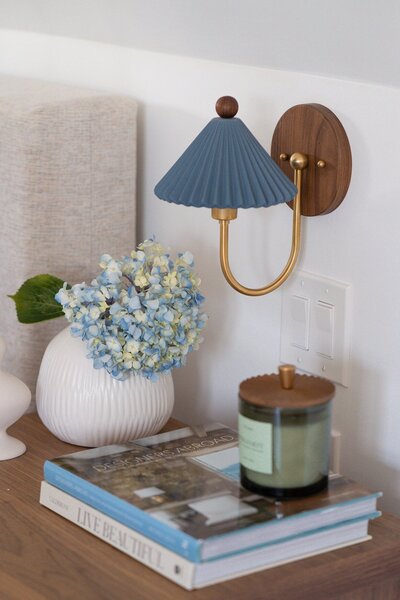 Vase of flowers and coffee books on black modern bedside table