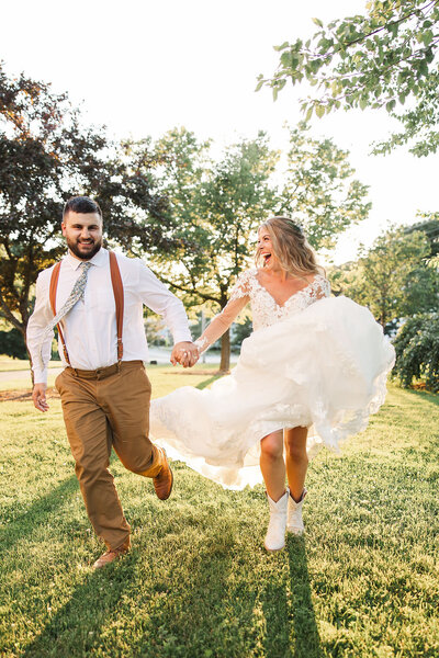 Picture of a bride and groom holding hands running together.  Photo taken by Pittsburgh Wedding Photographer, Sara Haines