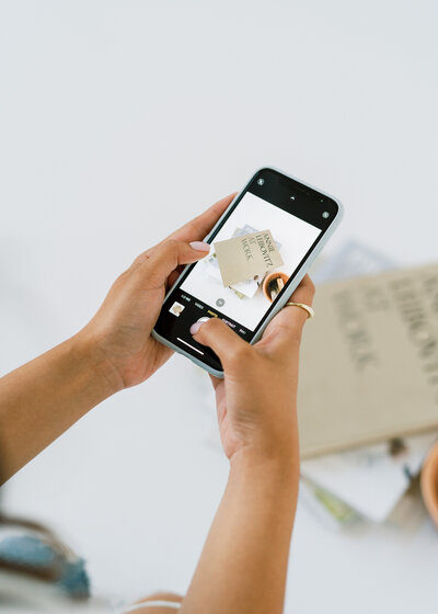 Girl using phone to take picture of books