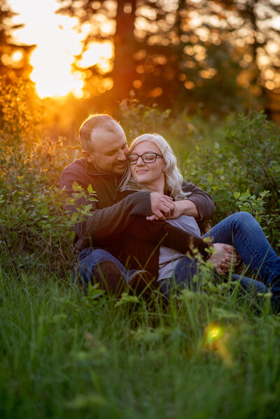 couples sitting in grass at golden hour