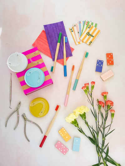 Bright and colorful flatlay of toothbrushes and dental props