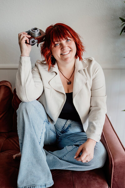 Allison siting on a chair holding a camera in hand