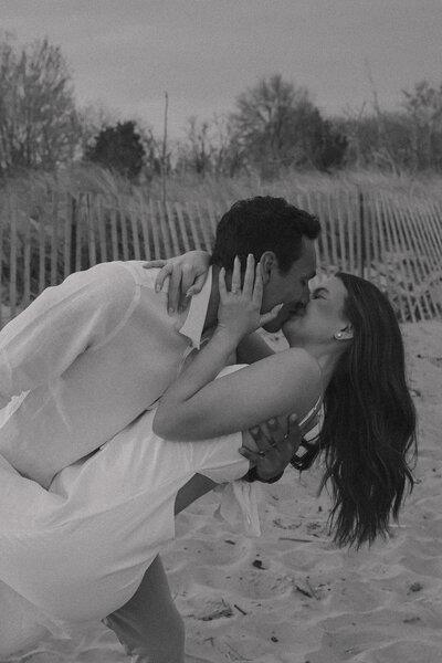 A couple kissing during their engagement session on the beach near Annapolis, Maryland