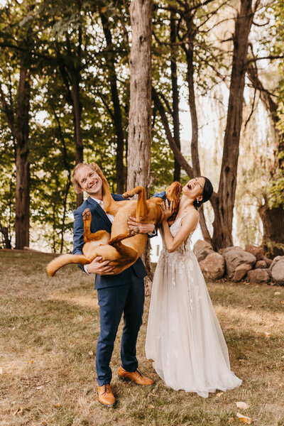 bride and groom holding their dog