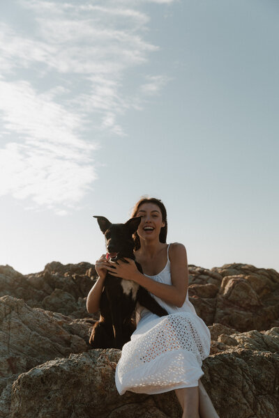This is me with my dog sitting on a rock at the beach looking at the camera