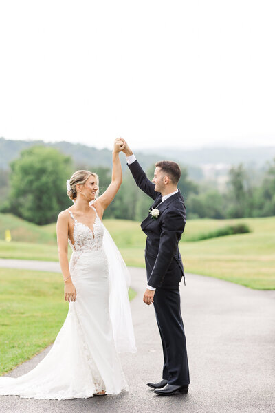 Groom spins bride outside at SkyView Golf Club in Sparta New Jersey Wedding 