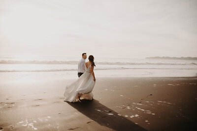 bride and groom walking down the beach