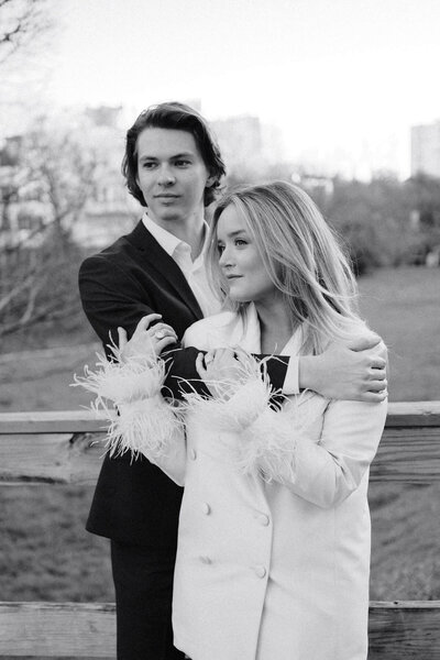 a black and white engagement session photo of a couple of the girl wrapped in the mans arms in dallas texas