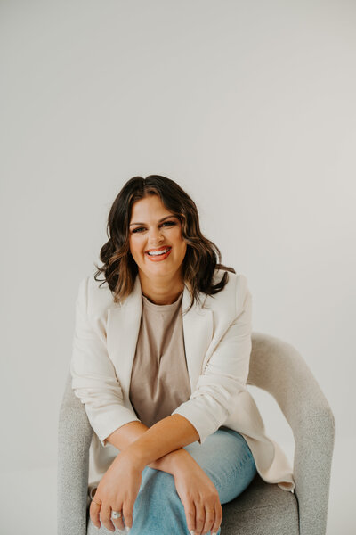 Online business mentor for coaches sitting confidently, helping women scale with strategy-first marketing