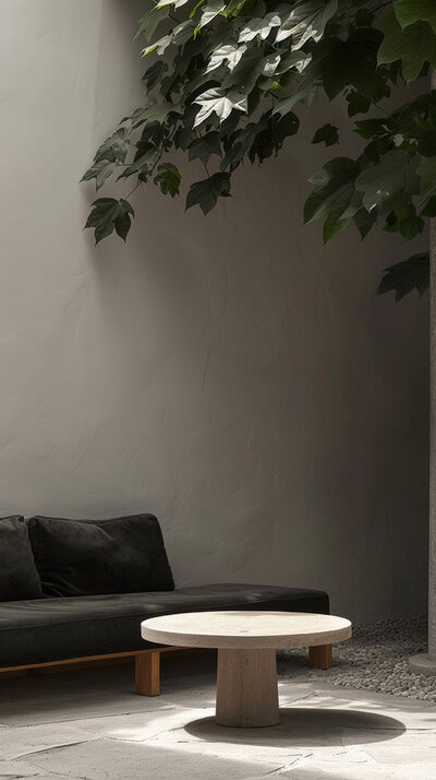 Minimalist living space with stone bust, modern grey sofa, and wooden coffee table - Baer Brand Studio aesthetic