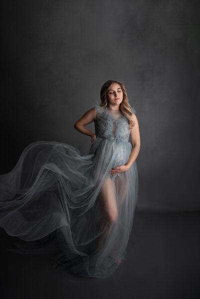 Pregnant woman wearing a blowing gray tulle gown  photo taken at her Southeast Michigan Maternity Session
