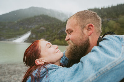 couple cuddling together on top of cliff