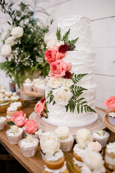 Detail photo of bride and bridesmaid holding Anemone bouquets with heavy greenery and white roses