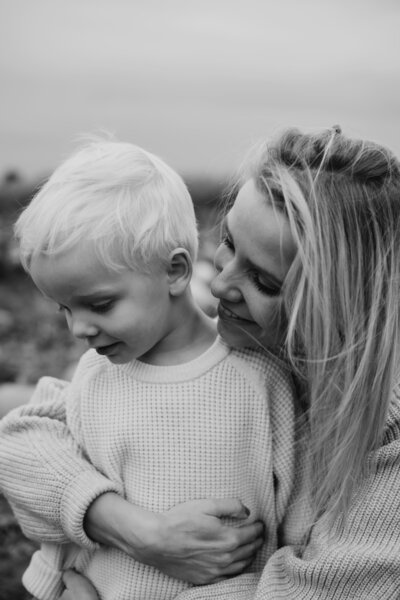 Schwarz weiss Bild von Mutter und Sohn, wie sie ihn im Arm hält