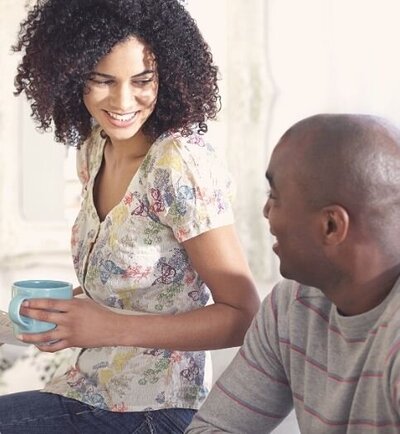 A couple smile at one another as they appear to talk about something over coffee. This could represent a couple benefiting from couples communication therapy in Florida. Contact Idit Sharoni to learn  more about communication therapy for couples in Florida and other services.