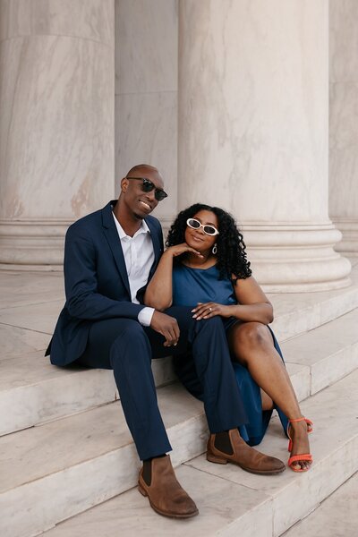 engagement photo couple wearing sunglasses sitting on marble stairs