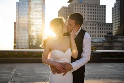 Bride and groom share a romantic rooftop kiss at sunset during their Jewish wedding at JPS Event Center in downtown Indianapolis.

