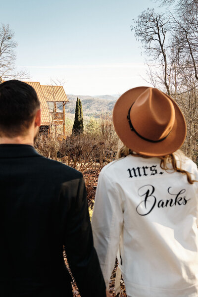 Elopement couple look at the cabin they eloped at