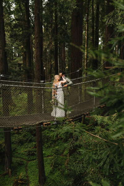 bride and groom on bridge in the redwoods