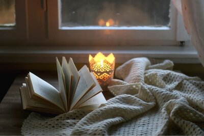 A book resting peacefully on a pristine white bed.