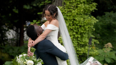 groom holding bride while they smile at each other