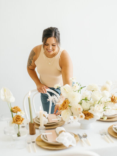 Austin wedding planner styling a modern reception tablescape with neutral florals, custom stationery, and candles, designed by Eventive Designs.