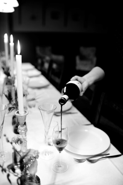 Sweet Pea Ink Creative | Brand Identity -  black and white image of red wine being poured into glass with romantic tablescape