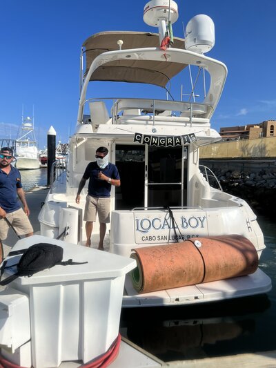 A man stands at the rear of a boat, representing the elegance and excitement of a destination wedding experience.