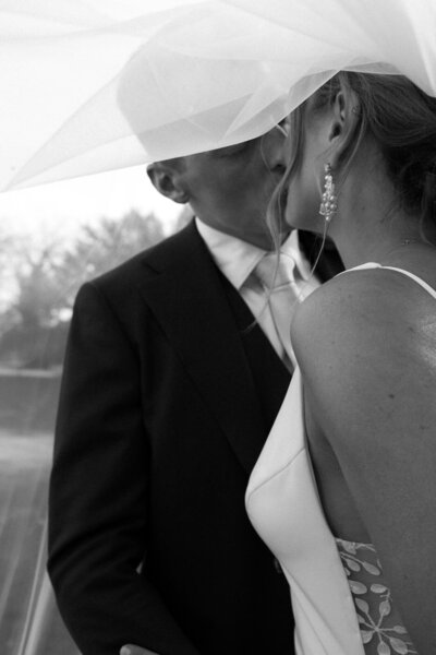 Bruidspaar zoent onder sluier door trouwfotograaf in Nederland Linda Photography