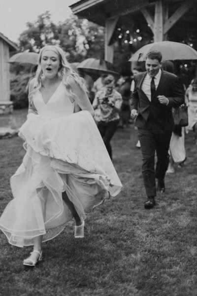 bridal couple running through grass