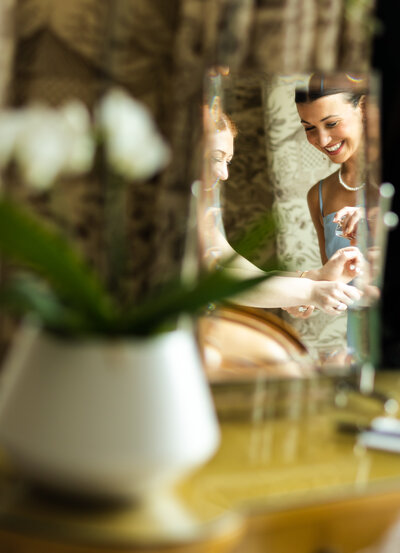 Maid of honor sprays perfume for bride in the Presidential Suite at The Four Seasons Boston, Massachusetts