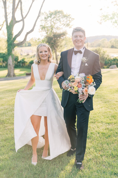 Bride and groom walking in front of their wedding venue in Leesburg, Virginia at golden hour.