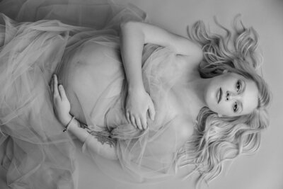 black and white portrait of a woman's pregnant belly wrapped in sheer fabrics, Indianapolis maternity photographer