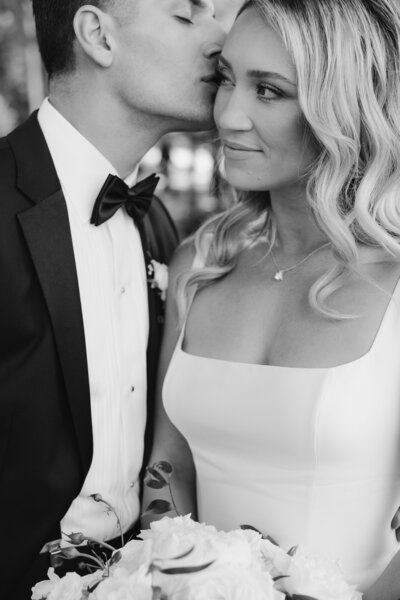 bride and groom snuggling together in a black and white photo