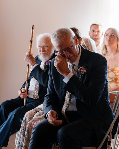A wedding guests wiping away a tear