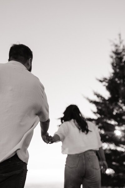 Engaged couple run hand in hand in Mount Tamalpais