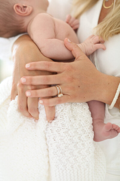 woman's hands holding a baby