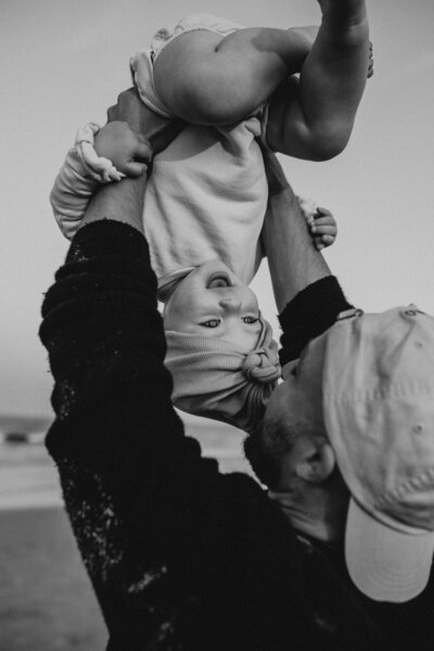 Baby hanging upside down with dad