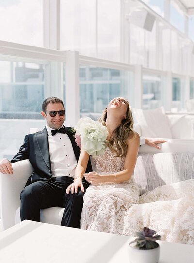 Bride and Groom On Couch Laughing
