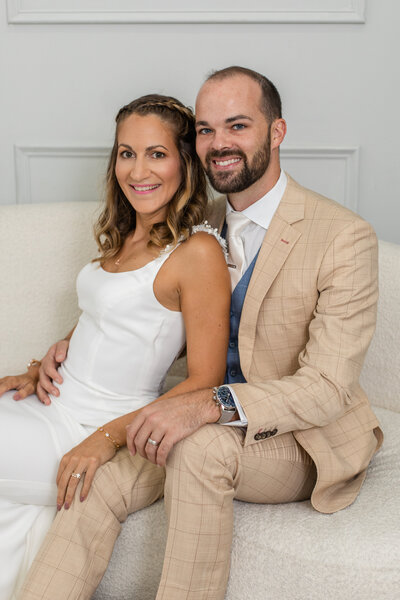 couple sitting on a studio sofa during photoshoot by Laure photography